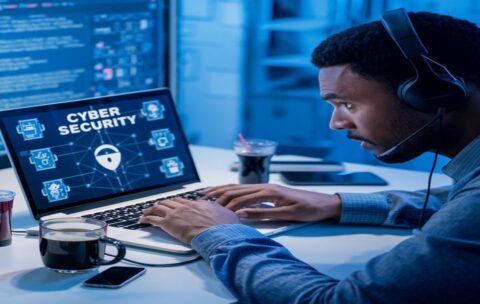 A man is working on a laptop with a screen that says'cyber security'on it